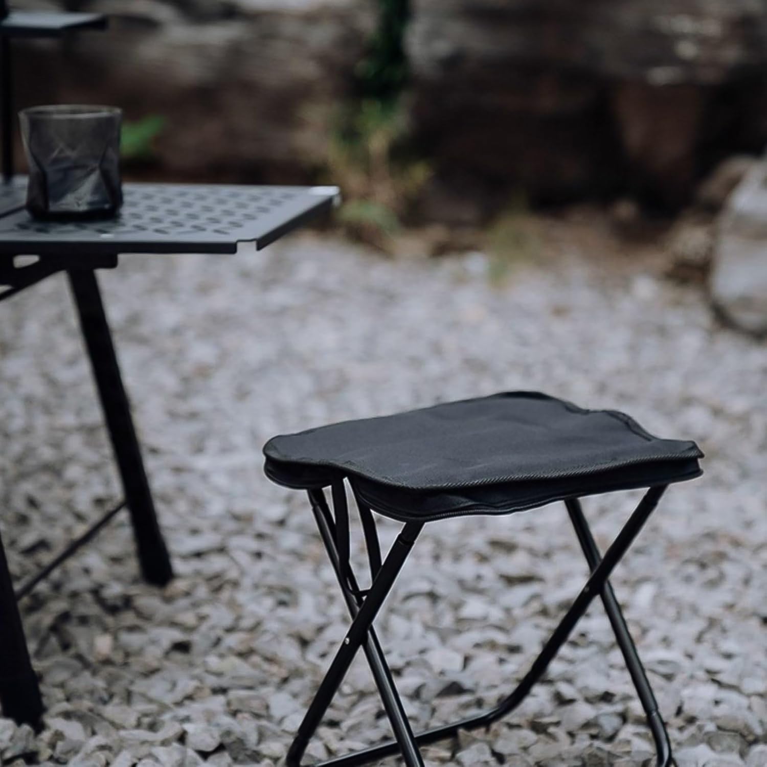 Portable camping stool shown folded, highlighting its slim profile for transport.
