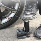 A person using the foot bike pump to quickly inflate a sports ball.