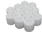 Several LED tealight candles illuminating a dark setting, showing their warm glow.